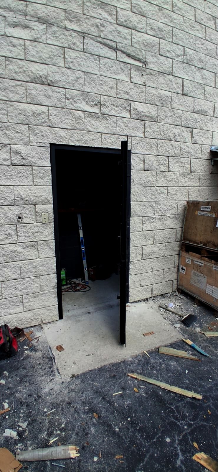 Custom steel door being installed by Fine Edge Industries at a commercial facility in Doral
