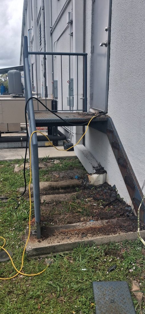 Corroded exterior steel stair showing rust and salt-air corrosion, South Florida — Fine Edge Industries