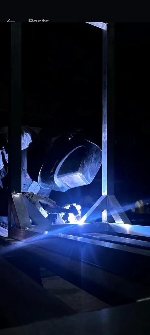 Fine Edge Industries welder striking an arc during on-site field welding, South Florida